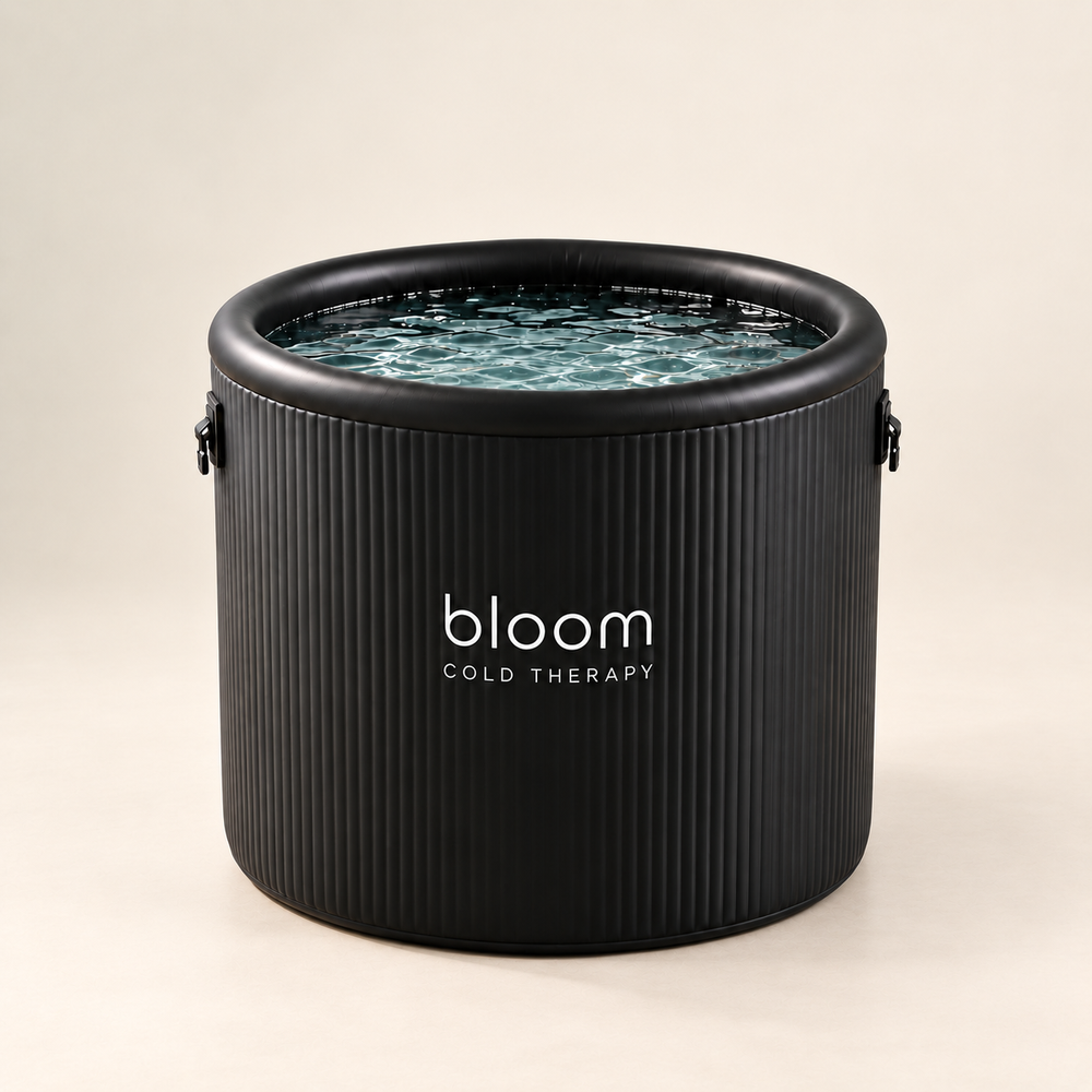 Bloom Ice Pro Tub with black ribbed walls and water, photographed against a soft warm ivory studio backdrop.