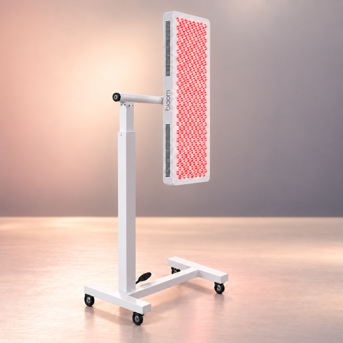 Bloom Red Pro with illuminated staggered lenses on its pneumatic stand, with a central side mount and a charcoal taupe Bloom wordmark in a soft peach and warm taupe studio